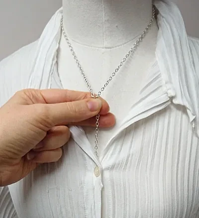 Mesure d'une chaine de collier sur un mannequin habillée d'une chemise
