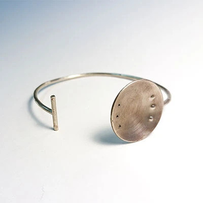 bracelet à embout T et plaque ronde poiçonnée de métal