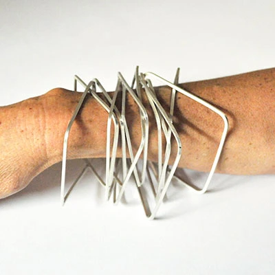 Superposition de bracelets rectangulaires en métal sur un bras