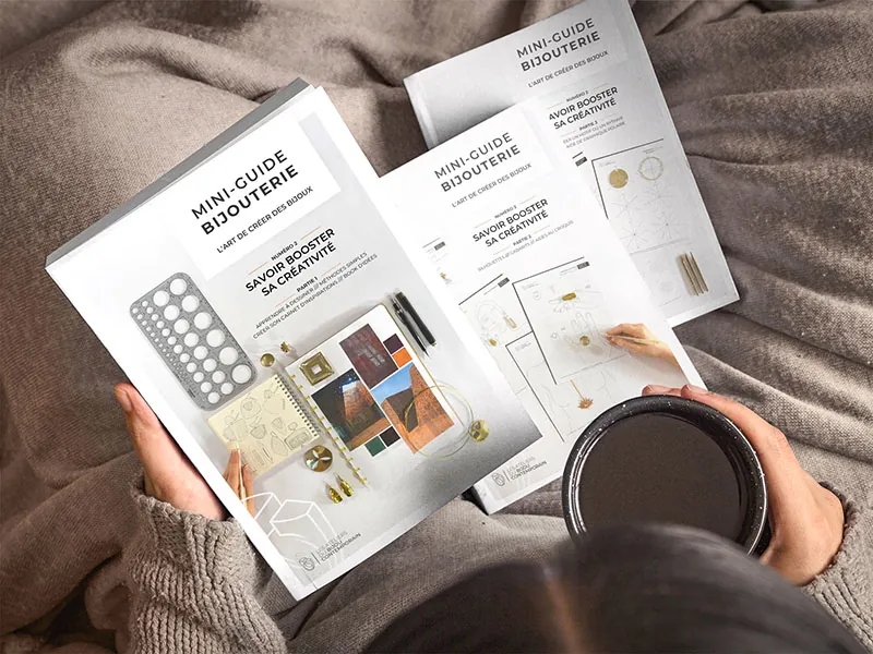 Artisan feuilletant un mini-guide de bijouterie des Ateliers du Bijou Contemporain