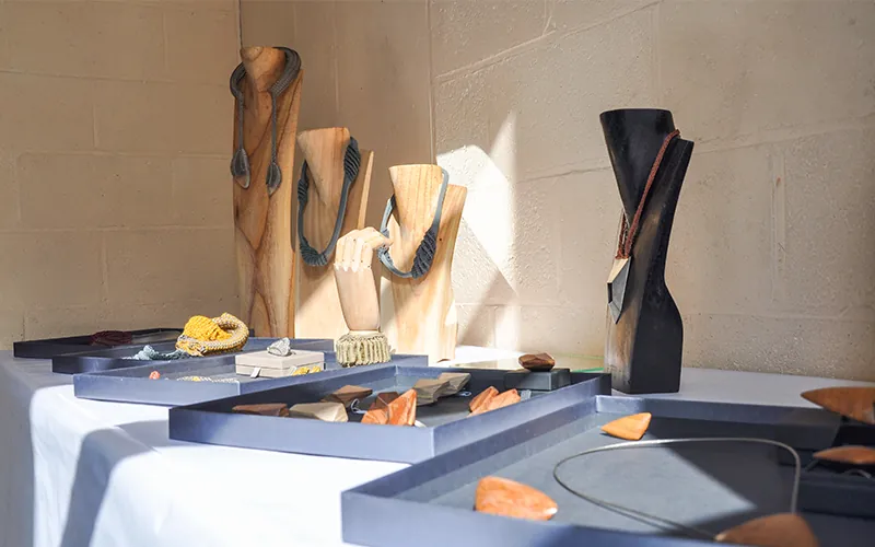 Un stand lumineux avec des présentoirs texturés pour bien présenter les bijoux