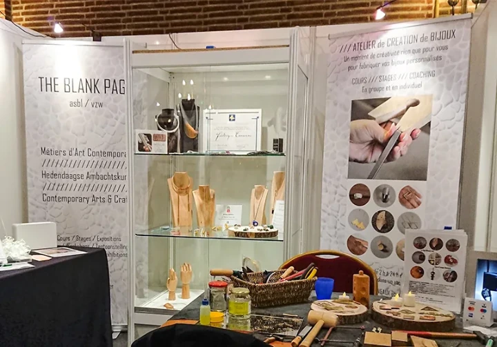 Présentation d'un stand typique de créateur avec une vitrine, une table et des affiches