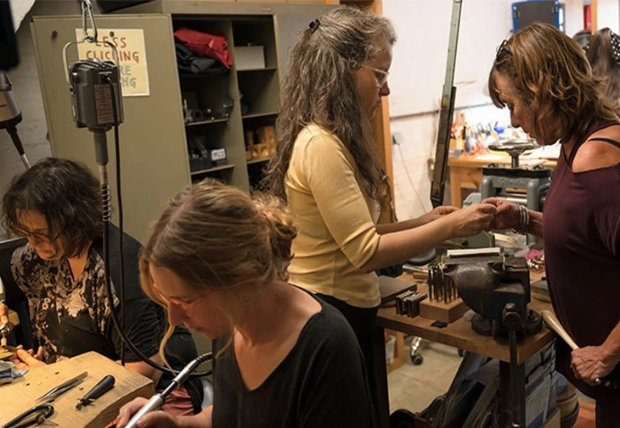 élèves travaillant le métal à leur établi de bijoutier lors d'un atelier à bruxelles