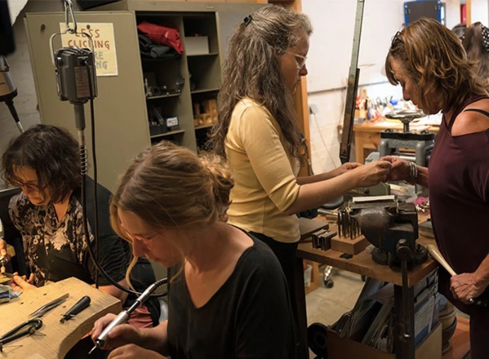élèves travaillant le métal à leur établi de bijoutier lors d'un atelier à bruxelles